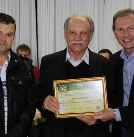 Empresário Osvino Ricardi (no centro), recebendo o certificado do 