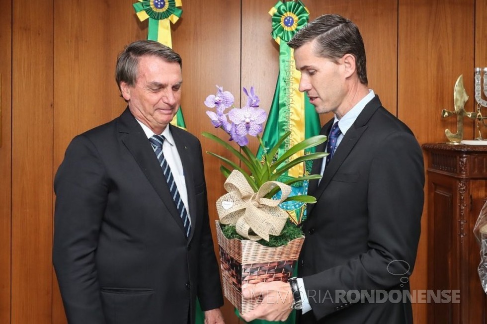 Anderson Bento Maria (e), ex-prefeito de Maripá (PR), entregando ao presidente da Repúblicam Jair Messias Bolsonaro, uma de orquídea, de um orquidário do município, que é conhecido como a 