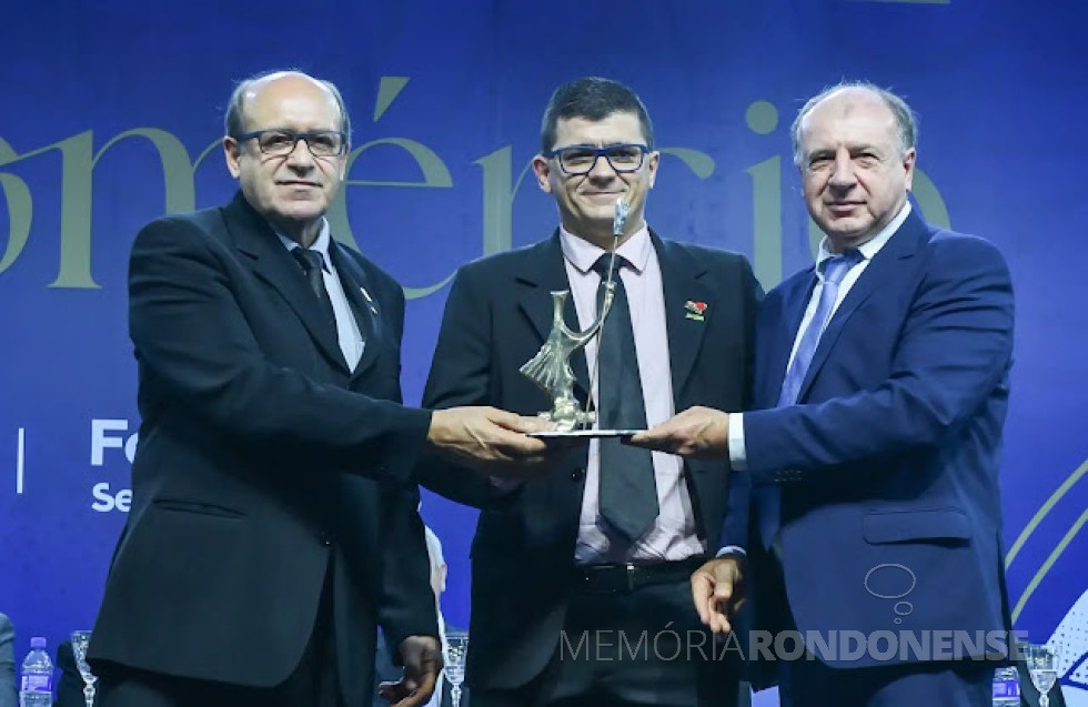 Aliandro Barbosa, da cidade Palotina, recebendo o troféu Guerreiro do Comércio 2022, em julho de 2022. 
À direita, é João Carlos Ortega, chefe da Casa Civil do Governo do Paraná.
Imagem: Acervo Fecomércio - FOTO 13 -