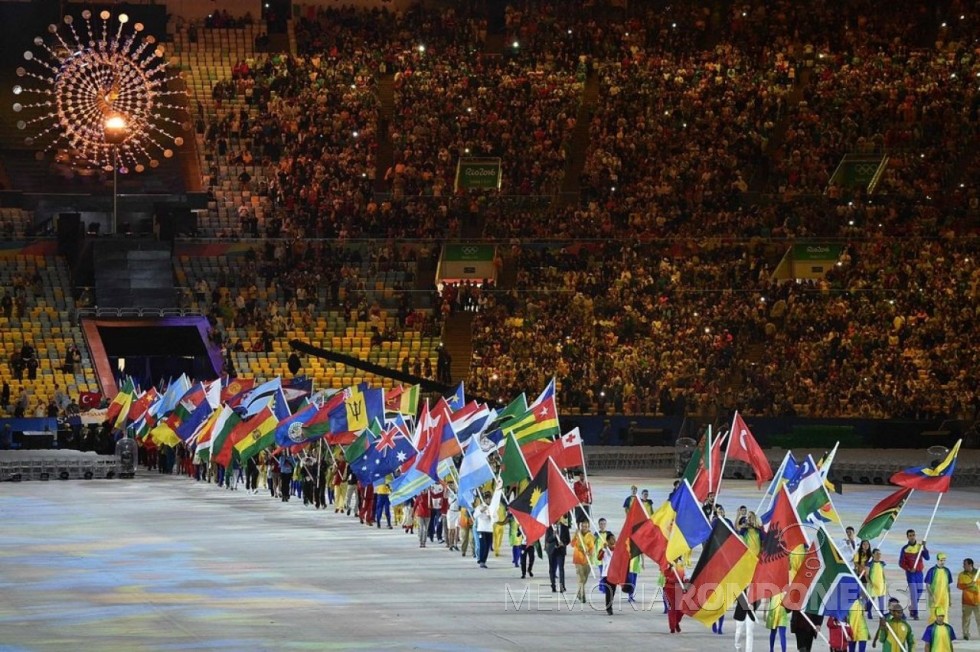 Entrada de atletas que participaram da Rio 2016, no estádio do Maracanã, com a bandeira de seu  respectivo pais. 
Imagem: Reprodução - FOTO 7  -  